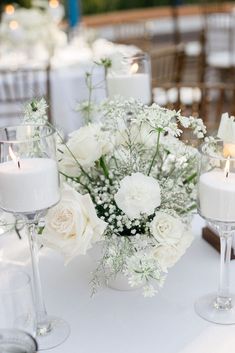 white flowers and candles are on the table