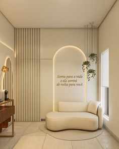 a living room with a white couch and some plants on the side table in front of it