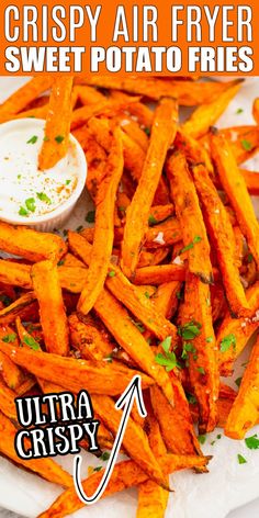 crispy air fryer sweet potato fries on a plate with dipping sauce and parsley