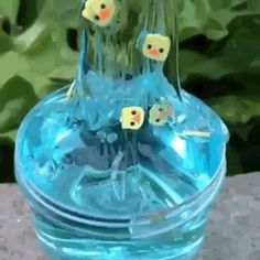 there is a blue glass vase with little birds in it and water on the table