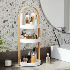 a bathroom counter with three tiered shelves on it