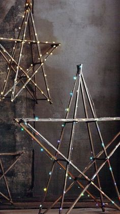 three wooden sticks are arranged in the shape of starbursts with multi - colored lights