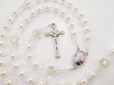 "- Personalized handmade rosary made with white Czech glass pearls and big white Czech cathedral glass beads - Choice of medals and letters - Comes with a velour pouch and gift box This white handmade baptism rosary is made with white Czech glass pearls and crystals and big antique looking Czech cathedral beads. It has a beautiful vintage look. Comes with your choice of Baptism, First Communion, Confirmation, or other medals. Read below for details. Over 80 colorful designs to choose from. Enter Adjustable White Rosary For First Communion, Personalized White Rosary For Confirmation, Elegant Round Beads Rosary For First Communion, Spiritual 8mm Beads Rosary For Baptism, White Spiritual Rosary For Baptism, White Rosary Bracelet For First Communion, White Rosary With Round Beads For First Communion, Rosary Bracelet With 8mm Round Beads For Baptism, White Rosary With Round Beads For Confirmation