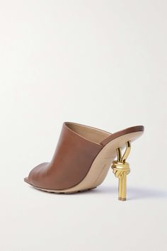 Bottega Veneta's mules sit on 85mm gold-tone heels that look as if they've been tied into a knot. Made from supple leather, they have distinct square toes and rubber grips on the sole to keep you from slipping. Luxury Gold Mules With Padded Heel, Luxury Gold Open Heel Mules, Gold Calf Leather Heels With Pointed Toe, Gold High Heel In Calf Leather, Gold High Heel Calf Leather Heels, Luxury High Heel Mules With Wrapped Heel, Luxury High-heeled Mules With Wrapped Heel, Luxury Mules With Wrapped Heel For Formal Occasions, Luxury Formal Mules With Wrapped Heel