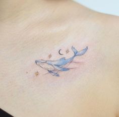 a woman's stomach with a tattoo of a whale and the moon on it