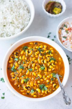 a white bowl filled with corn and rice next to two bowls full of rice on the side