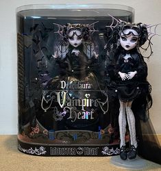 two dolls dressed in black and white are standing next to each other