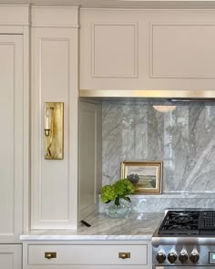 a stove top oven sitting inside of a kitchen next to white cupboards and drawers