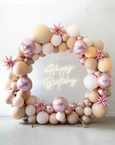 a happy birthday balloon arch with pink and white balloons in the shape of a wreath