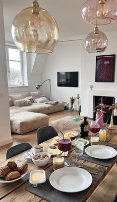 a wooden table topped with lots of plates and bowls filled with breakfast food next to a fire place