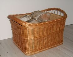 a wicker basket with logs in it on the floor