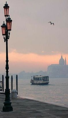 a boat is in the water next to a lamp post