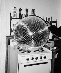 a disco ball sitting on top of a stove in a kitchen next to a wall