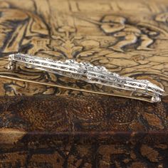 A stunning platinum and diamond bar brooch from the Edwardian era with beautiful and delicate milgraining.Item #JP-P0007Metal: PlatinumWeight: 12 GramsDiamond Weight: Approximately 3.50 ctsDiamond Color: HDiamond Clarity: VS2Measurements: 17 x 66 mmLayaway: For your convenience, we will be happy to provide layaway payment options. Please contact us to work out a layaway plan which best suits your needs. All layaway purchases are final sale.All domestic and international shipments are shipped wit Classic Diamond White Diamond Brooch, Classic Diamond White Brooch For Anniversary, Classic Platinum Brooches With Diamond Accents, Classic Platinum Brooch With Brilliant Cut, Classic Platinum Brooches, Classic Diamond Brilliant Cut Brooch, Classic Diamond Brooch With Brilliant Cut, Classic White Gold Diamond Brooch, Classic Platinum Brooch For Anniversary