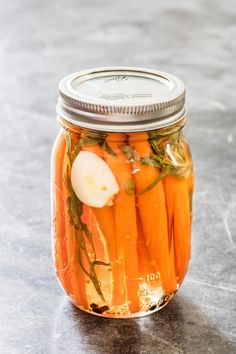 a glass jar filled with carrots and onions