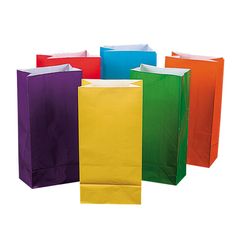 several different colored paper bags on a white background