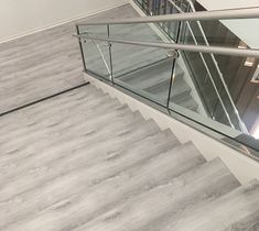 a stair case with glass railing and handrail