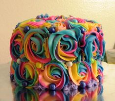 a multicolored cake sitting on top of a table