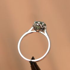 It is a green sapphire ring. The main stone is 7 mm*7 mm round cut.weight about 1.66 carats. The basic metal is sterling silver and plated with rhodium/14k white gold/14k rose gold/14k yellow gold You can also go to my shop Home for more elegant rings: https://www.etsy.com/shop/godjewelry?ref=hdr_shop_menu Customization is always welcome and please feel free to contact with me if you have any design ideas! Green Sapphire Ring With Halo Setting For Promise, Silver Tourmaline Emerald Ring, Green Sapphire Ring For May Birthstone In Sterling Silver, Green Sapphire Ring With Prong Setting For May Birthstone, Green Sapphire Ring Sterling Silver, May Birthstone, Green Sapphire Sterling Silver Ring For May Birthstone, Green Sapphire Ring With Sterling Silver, Green Emerald Ring In Sterling Silver With Halo Setting, Green Solitaire Sapphire Ring In Sterling Silver