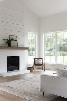 a living room with white walls and wood floors