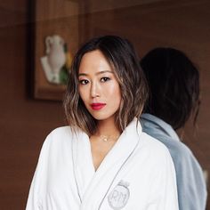 a woman in a bathrobe looking at the camera