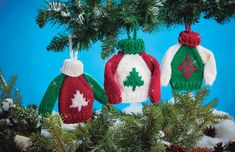 three knitted christmas sweater ornaments hanging from a tree