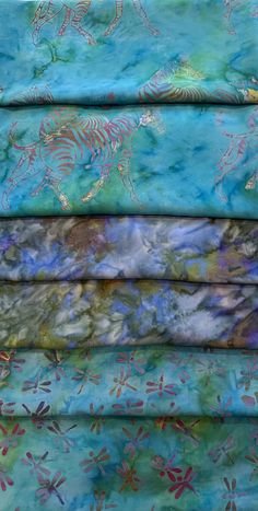 four pieces of fabric with different patterns and designs on them, all in shades of blue