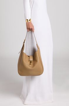 Signature T-shaped hardware adds a heritage touch to this slouchy hobo bag masterfully crafted in Italy from beautifully grained calfskin leather. Hook-tab closure Shoulder strap Leather Made in Italy Designer Handbags Timeless Hobo Bag With Gold-tone Hardware For Office, Timeless Hobo Bag With Smooth Grain, Timeless Hobo Bag With Gold-tone Hardware For Work, Timeless Smooth Grain Hobo Bag, Classic Hobo Bag With Gold-tone Hardware For Work, Everyday Calf Leather Shoulder Bag With Brass Hardware, Timeless Formal Hobo Bag With Gold-tone Hardware, Calf Leather Shoulder Bag With Brass Hardware For Everyday, Timeless Hobo Bag With Gold-tone Hardware