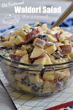 a bowl filled with food sitting on top of a blue and white table cloth next to a wooden spoon