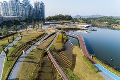 an aerial view of a river and train tracks in the foreground, with high rise buildings in the background