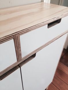 a white cabinet with two drawers on top of it