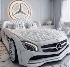 a white bed with a mercedes logo on the headboard and foot board in front of it