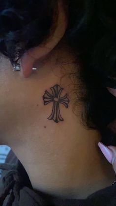 a woman with a cross tattoo on her neck