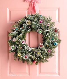 a pink door with a wreath hanging on it