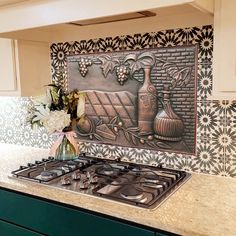 a stove top oven sitting inside of a kitchen next to a vase filled with flowers