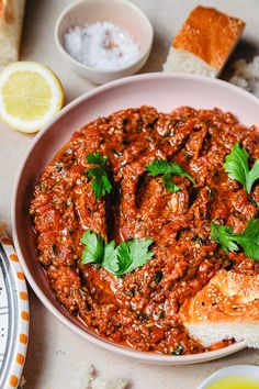 a bowl filled with meat covered in sauce and garnished with cilantro