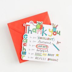 a thank you card with an apple and pencil on the front is in red envelope