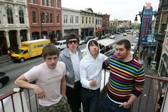 four young men standing next to each other