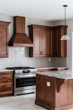 a large kitchen with wooden cabinets and marble counter tops, along with stainless steel appliances