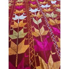 a red and gold blanket with birds on it