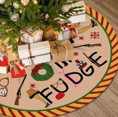 a christmas tree with presents under it on the floor next to a sign that says happy holidays