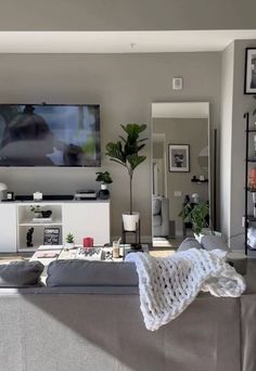 a living room filled with furniture and a flat screen tv mounted to the side of a wall