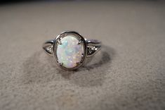 I am offering you this vintage  sterling silver fancy wedding band stacker design ring (stamped) . It features 3 total combination oval and round shaped genuine prong set opal stones. These stones are set in a fancy raised relief multi stone setting. Truly a most spectacular detailed Southwestern style ring. It is currently a size 7, though I am sure this could easily be sized up or down. It measures app. 3/4 inch, by app. 1/2  inch. It weighs app. 5  grams. Please review all of my pictures as t Oval Opal Ring For Anniversary, Stackable Oval Rings For Anniversary, Heirloom Oval Opal Ring For Anniversary, Silver Oval Cabochon Wedding Ring, Vintage Silver Opal Ring With Oval Shape, Silver Classic Opal Ring Round Cut, Classic Silver Opal Ring With Round Cut, Vintage Silver Oval Opal Ring, Classic Oval Opal Ring In Sterling Silver