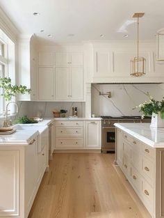 a large kitchen with white cabinets and wood flooring on the walls, along with an island in the middle