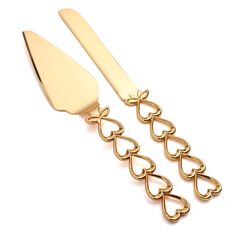 two gold heart shaped utensils on a white background