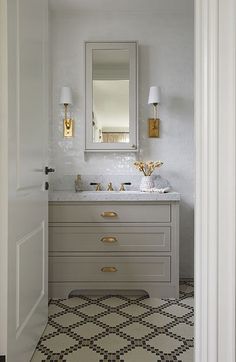 a bathroom with two sinks and a mirror above the sink is seen through an open door