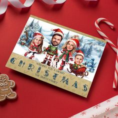 a christmas card with three people on it next to candy canes and gingerbread