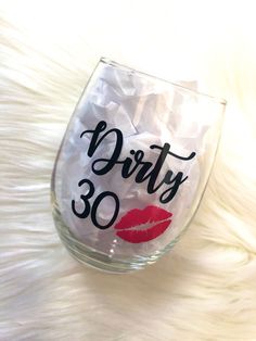 a wine glass with the words dirty 30 written on it and a red lipstick imprint