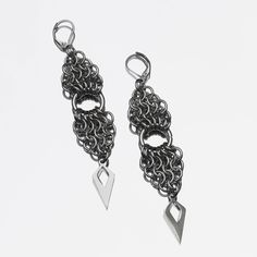 Ces boucles d'oreilles ont deux parties dans un pattern "European" en forme de triangle, liées par un grand anneau central. Ce design est renforcé par les perles de forme géométrique qui rappellent la forme globale. Elegant Triangle Metal Earrings, Modern Teardrop Stainless Steel Earrings, Gunmetal Dangle Jewelry, Gunmetal Dangle Earrings Metal Jewelry, Gunmetal Dangle Earrings, Elegant Triangle Metal Jewelry, Handmade Gunmetal Metal Jewelry, Elegant Handmade Stainless Steel Earrings, Minimalist Metal Earrings With Oxidized Finish