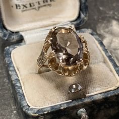 1970s vintage 9ct yellow gold smoky quartz ring. Stunning oval cut stone to a decorative scalloped style mount with textured detail to the gold shoulders typical of its era. In amazing condition having been cleaned and polished. Metal; 9ct yellow gold Hallmark; Birmingham, 375 Date; 1976 Stone; smoky quartz Stone size; 13 mm x 10 mm Carat weight; 4.13ct estimated Rise from finger; 8mm Condition; as above Weight; 3.8 grams Ring size; K.5 (UK) Size 5 3/8 (US)  Antique box is not included Will come Luxury Vintage Gold Crystal Ring, Luxury Antique Bronze Rings, Antique 14k Gold Oval Topaz Ring, Antique 14k Gold Topaz Ring, Antique Oval 14k Gold Topaz Ring, Antique Oval Topaz Ring In 14k Gold, Antique 14k Gold Hallmarked Topaz Ring, Vintage Faceted Yellow Gold Rings, Victorian Oval Gold Topaz Ring